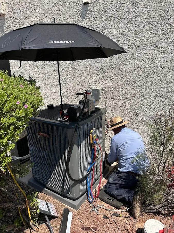 HVAC technician performing outdoor AC maintenance in Oak Creek